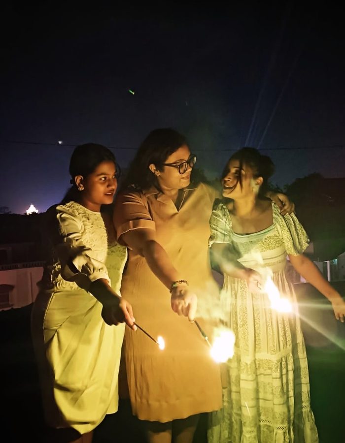 Payel and friends holding sparklers at night