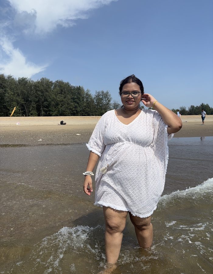 Payel walking in the waves on a beach